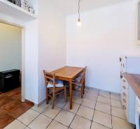 Küchenecke mit Tisch in einer 2-Zimmer-Wohnung, in der Nähe des Badezimmereingangs.