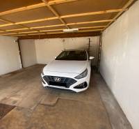 Der Innenraum der Garage mit einem weißen Hyundai-Auto, das drinnen geparkt ist.