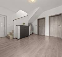 Flur mit Treppe und drei Türen in einer 4-Zimmer-Wohnung mit Kommode und Garderobe.