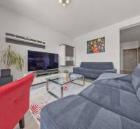 Wohnzimmer in einer 4-Zimmer-Wohnung mit Fernseher, Sofas und Innendekorationen.