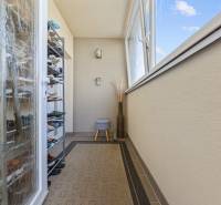 Balkon in einer 4-Zimmer-Wohnung mit Schuhschrank, Teppich, Verglasung, offenes Fenster.