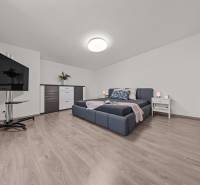 Helles Schlafzimmer mit großem Bett, Fernseher und Kommode in einer 4-Zimmer-Wohnung.