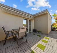 Terrasse mit Sitzbereich in einer 4-Zimmer-Wohnung mit Grünfläche und Markise in der Záhradná-Straße.