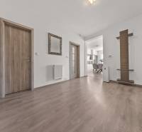 Flur einer 4-Zimmer-Wohnung mit Holztüren, Spiegel und Blick in die Küche.