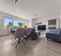 Wohnzimmer in einer 4-Zimmer-Wohnung mit Esstisch, Sofa und Fernseher.