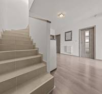 Eine Treppe in einer 4-Zimmer-Wohnung mit Holzboden und weißen Wänden.