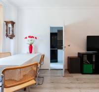 Esszimmer in einer 4-Zimmer-Wohnung mit Holzstühlen, Fernseher und roter Vase.