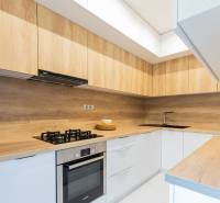 Küche einer 4-Zimmer-Wohnung mit Holzschränken und eingebauten Geräten.