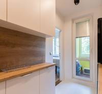 Küche in einer 4-Zimmer-Wohnung mit Holzarbeitsplatte und Zugang zum Balkon.