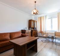 Wohnzimmer mit Sofa, Holztisch und Stühlen in einer 4-Zimmer-Wohnung.