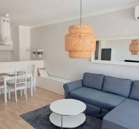 Gemütliches Wohnzimmer mit Küche in einer 2-Zimmer-Wohnung mit elegantem Möbeln und Beleuchtung.