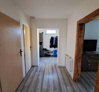 Flur im Einfamilienhaus mit Laminatboden, Holzrahmen und Schuhlager.
