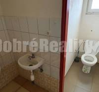 Toilette mit Waschbecken und Urinal in Geschäftsräumen.