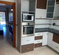 Küche in einem Einfamilienhaus mit Mikrowelle, Ofen und Glastüren an den Schränken.