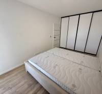 Schlafzimmer in einer 2-Zimmer-Wohnung mit Einbauschrank und Holzboden.
