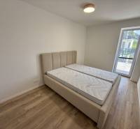 Schlafzimmer mit Doppelbett, Matratzen und Holzboden in einer Zweizimmerwohnung.