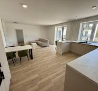 Zweizimmerwohnung mit hellem Wohnzimmer und Küche mit Holzboden.