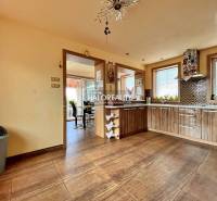 Eine Küche in einem Einfamilienhaus mit Holzmöbeln und Keramikfliesen.