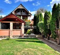 Ein Einfamilienhaus in Levice mit einem gepflegten Garten, einem Pavillon und Bäumen.