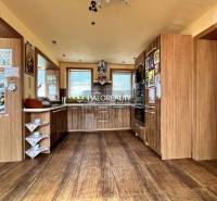 Küche in einem Einfamilienhaus mit Holzschränken und eingebauten Geräten.