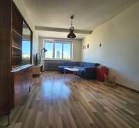 Wohnzimmer in einer 2-Zimmer-Wohnung mit einer Eckcouch und Holzboden.