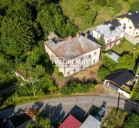 Luftaufnahme eines Gebäudes, umgeben von Grünflächen und benachbarten Häusern im Dorf Hodruša-Hámre.