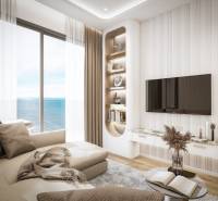 Wohnzimmer in einer 3-Zimmer-Wohnung mit Meerblick, bequeme Couch, Fernseher an der Wand.