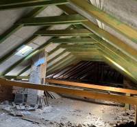 Decke von Geschäftsräumen mit Holzkonstruktion und Baumaterial, das über den Boden verstreut ist.