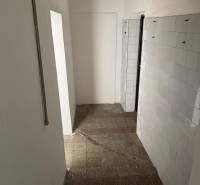 Schmaler Innenraum mit Fliesenboden und Wandverkleidung in Geschäftsräumen.