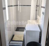 Badezimmer in einer 2-Zimmer-Wohnung, mit Waschmaschine und Duschkabine.