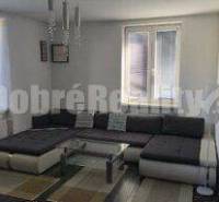 Wohnzimmer in einer 2-Zimmer-Wohnung mit großem Sofa und Fenster.