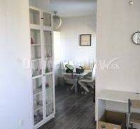 Interieur einer 2-Zimmer-Wohnung mit dunklem Boden und weißen Möbeln.