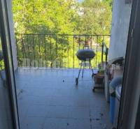 Balkon mit Grill und Blick ins Grüne in einer 2-Zimmer-Wohnung.