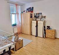 Zimmer mit Bett, Schränken und Dekorationen in einer Einzimmerwohnung.