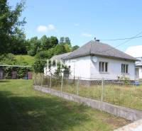 Ein Einfamilienhaus in Nižná Jablonka mit einem eingezäunten Garten, umgeben von Bäumen und Rasen.