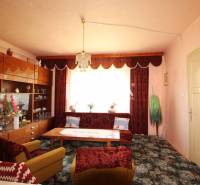 Wohnzimmer mit Retro-Möbeln, Teppichen und Vorhängen in einem Einfamilienhaus.