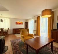 Wohnzimmer in einem Einfamilienhaus mit einem bequemen Sessel, Fernseher und Esstisch.