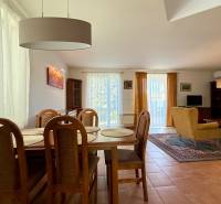 Esszimmer und Wohnzimmer in einem Einfamilienhaus mit Holzmöbeln und einem großen Teppich.