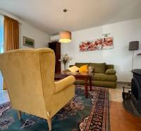 Wohnzimmer in einem Einfamilienhaus mit Sessel, Sofa, Kamin und Bild an der Wand.
