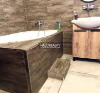 Ein Badezimmer in einem Einfamilienhaus mit eingebauter Badewanne und einem Waschbecken aus Holz.
