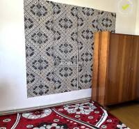 Schwarz-weiße geometrische Tapete, Holzschrank und Blumenmusterteppich in einem Einfamilienhaus.