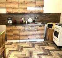 Küche in einem Einfamilienhaus mit Holzschränken, Herd und Kühlschrank.