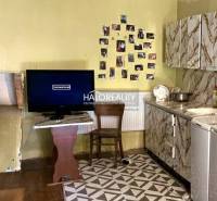 Küche in einem Einfamilienhaus mit Fernseher, Fotos an der Wand und Herd.