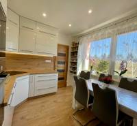 Küche in einer 4-Zimmer-Wohnung mit hellen Möbeln und Esstisch.