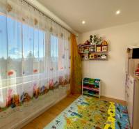 Kinderzimmer in einer Vierzimmerwohnung mit Spielzeug und einem bunten Teppich auf dem Boden.