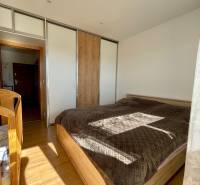 Helles Schlafzimmer mit großem Bett und Einbauschrank in einer 4-Zimmer-Wohnung.