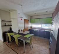 Küche in einem Einfamilienhaus mit Esstisch und grünen Details.