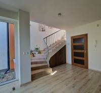 Ein heller Flur mit einer Holztreppe und einem Geländer in einem Einfamilienhaus.