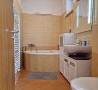 Badezimmer im Einfamilienhaus mit Eckbadewanne, Schrank, Waschbecken und Toilette.