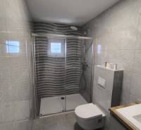 Badezimmer mit Dusche in einer 4-Zimmer-Wohnung, mit Fliesen und Fenster.